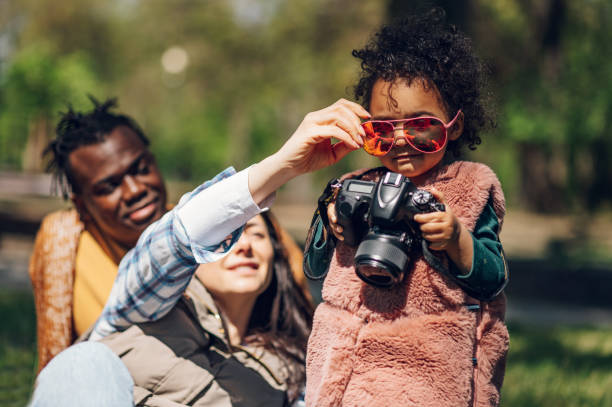 istock Beautiful multiracial family using a digital camera in the park. 1397117061