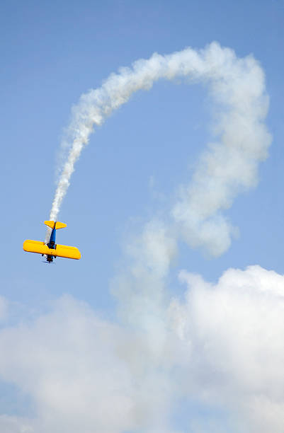 2 面と曲線の煙トレイル - airplane stunt yellow flying ストックフォトと画像