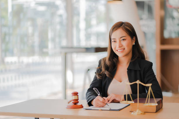 Lawyer's Office. Scales and hammer Asian female lawyer working with legal documents, advice and justice concepts. Lawyer's Office. Scales and hammer Asian female lawyer working with legal documents, advice and justice concepts. estate planning lawyer stock pictures, royalty-free photos & images