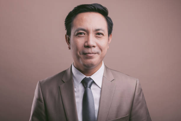 Asian businessman portrait, looking at camera. Smiling and laughing. Portrait medium shot stock pictures, royalty-free photos & images