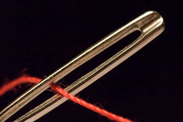 Running a red thread through an eyelet.