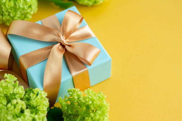 istock Image of a refreshing gift with a plain yellow background, a blue gift and a green viburnum Father's Day 1397130101