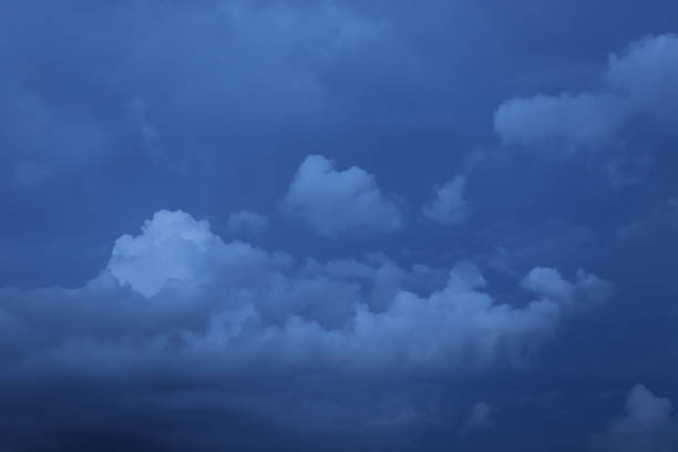 Contrasting white and dark gray clouds filling almost the entire blue sky in the photo