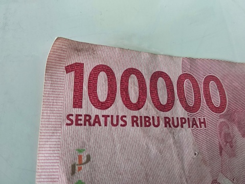 Close up Cut out Paper Money Indonesian banknote.100000 IDR Rupiah isolated on white background