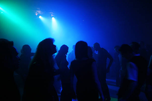 istock Silhouettes of people dancing against a blue lit background  139714471
