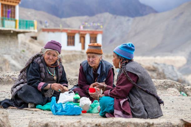 gli anziani buddisti bevono tè e mangiano cibo per strada vicino al monastero di lamayuru nel ladakh, nell'india settentrionale - tibet foto e immagini stock