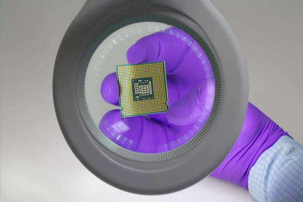 istock Hand in purple glove holding microchip under amagnifying glass . Focus on chip. 1397148508