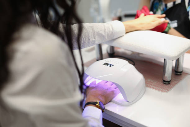 gel de secado lady en lámpara ultravioleta - manicura fotografías e imágenes de stock