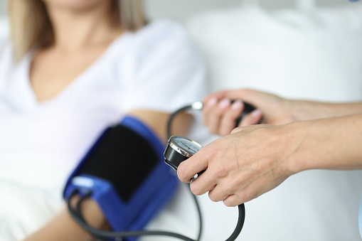 Doctor measures pressure with a tonometer to patient. Blood pressure rate concept