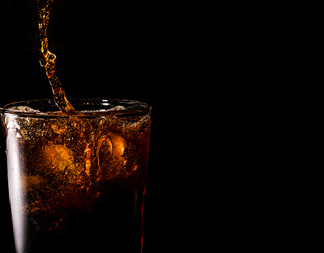 Close-up iced cola isolated in the black background