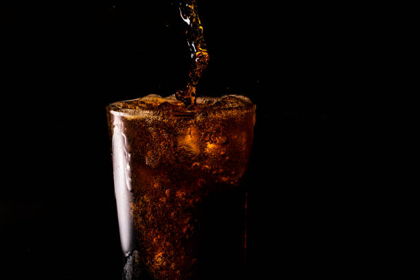 close-up iced cola isolated in the black background - coke coca cola pouring ice imagens e fotografias de stock