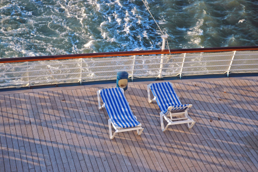Two empty deck chairs at the rear of a cruise ship