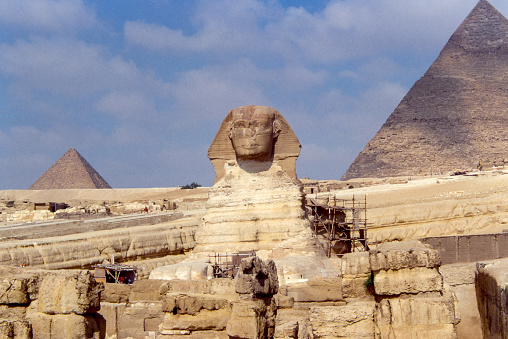 Giza, Cairo, Egirro - aug 04, 1991: view of the Sphinx, a symbol of enigma and mystery, lying on the desert sands in front of the famous Egyptian pyramids of Giza expression