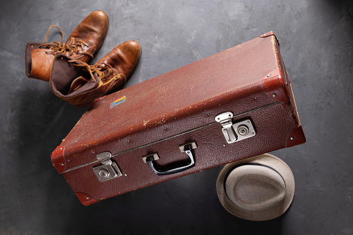 Old suitcase at abstract floor background texture. Travel concept idea