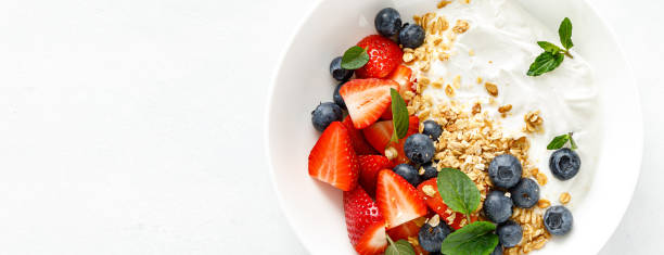 istock Breakfast bowl with granola, plain yogurt, strawberry and blueberry. Top view. Banner 1397159819