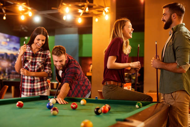 istock Group of friends having fun while playing pool in a local pool hall 1397161104