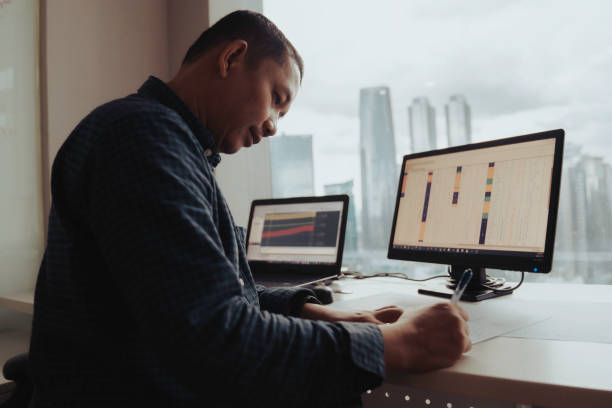 istock asian Architects Working On Blueprint and looking out on stunning Jakarta skyline 1397165267
