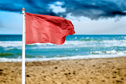 red warning flag on the beach