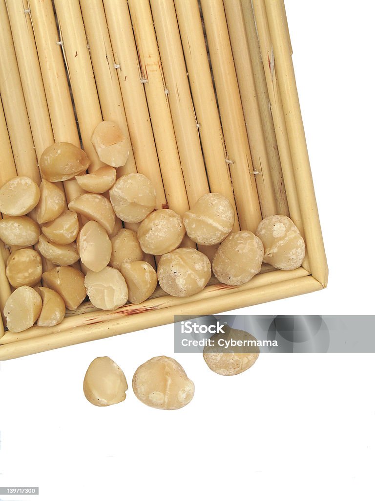 Nutty for nuts Macadamia nuts in bamboo basket container - some are halved, others whole. Bamboo - Material Stock Photo