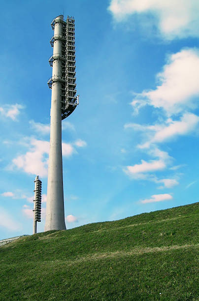 Two floodlight towers between sky and Earth stock photo