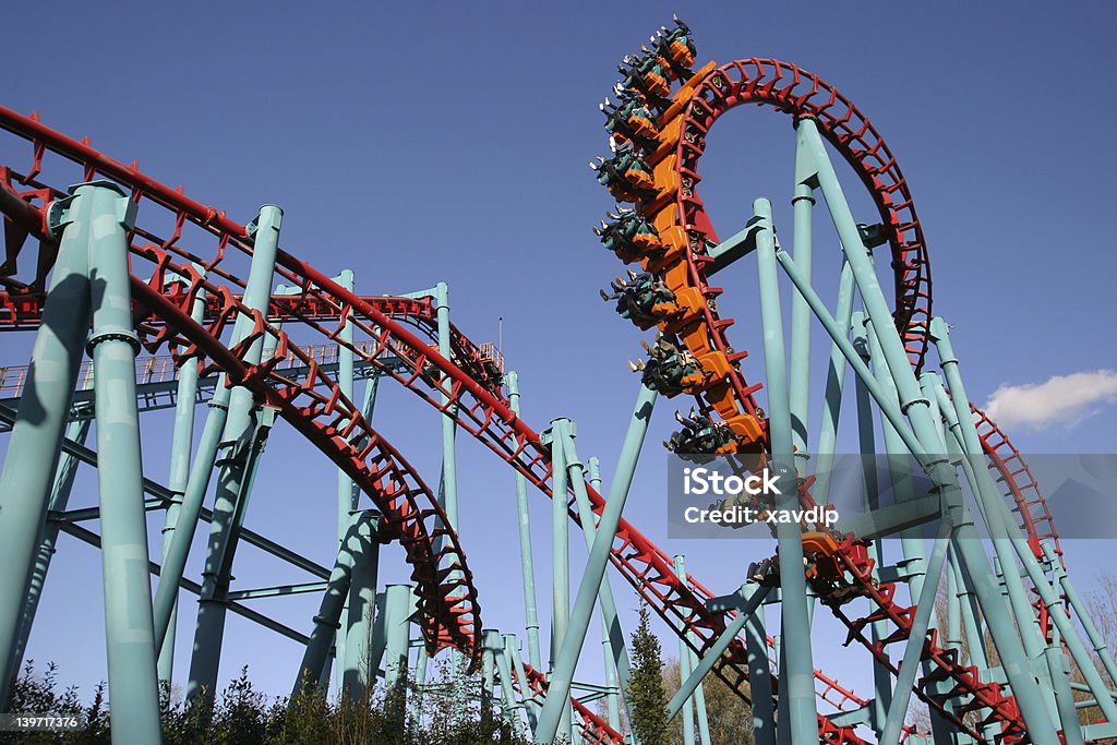 Peril upside down on a rollercoaster Red roller coaster and big blue sky Rollercoaster Stock Photo