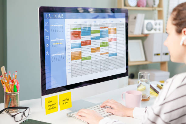 Freelancer woman using calendar on computer to improve time management, plan appointments, events, tasks and meetings efficiently, improve productivity, organize week day and work hours.