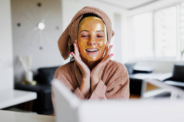 A beautiful woman pressing a sheet mask onto her face