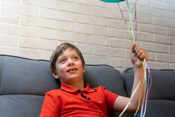 istock a happy preschool boy holds balloons in his hands 1397181575