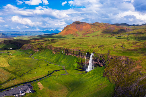Aerial view of Seljalandsfoss Waterfall, Seljalands River and waterfall parking in Iceland.