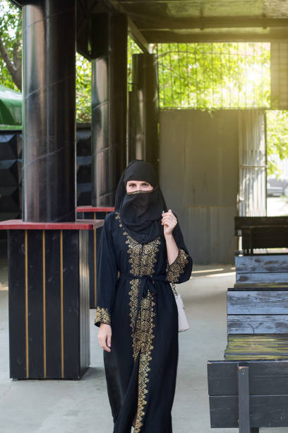 istock Muslim woman walking through an empty street cafe before opening 1397185707