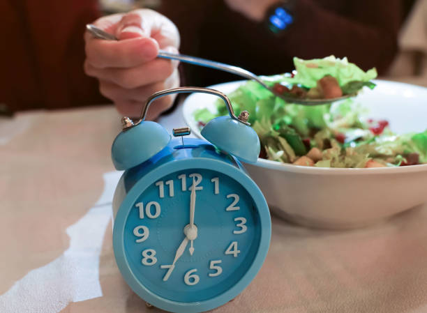 istock Blue larm clock which young man happy eating diet plan with  a Intermittent fasting low carb hight fats diet concept 1397186710