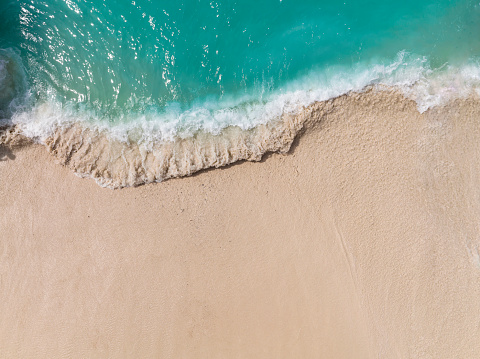 Top view of Soft wave of blue ocean on sandy beach. Background