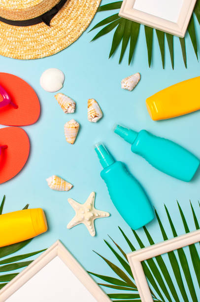 Summer fashion flat lay. Straw hat coral flip flops tropical palm leaves sunscreen white photo frame coconut seashells starfish on blue background. Top view copy space. Creative vacation background. piso de moda de verano. sombrero de paja chanclas de coral hojas de palma tropical protector solar marco de fotos blanco coco conchas marinas estrellas de mar sobre fondo azul. espacio de copia de vista superior. antecedentes creativos de vacaciones