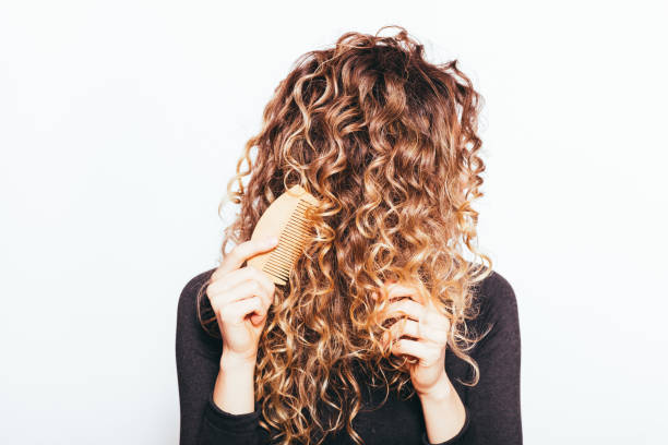 istock Young woman combing her naturally curly hair 1397187849