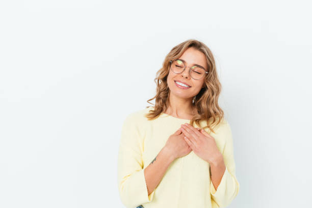 istock Thinkful happy young woman holding hands on chest 1397187871