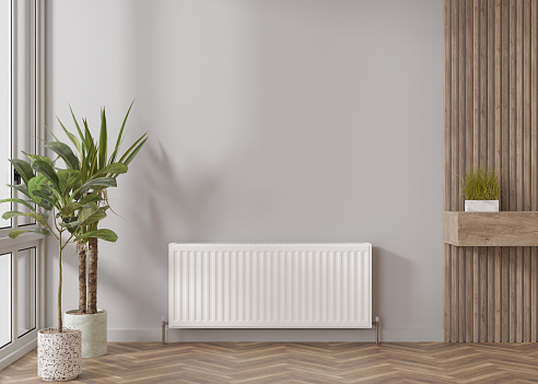 White heating radiator on grey wall in modern room. Central heating system. Free, copy space for your text. 3D rendering