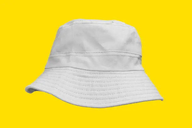 Photo of white bucket hat isolated on yellow