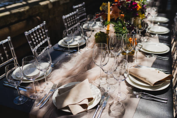 istock Table setting at the wedding reception. Floral compositions with beautiful flowers and greenery, candles, laying and plates on a decorated table. 1397201316