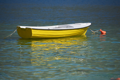 Vibrant Yellow boat in sea without people.