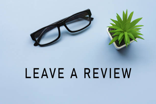 Leave a review text on office desk with potted plant and glasses. Leave a review text on office desk with potted plant and glasses on blue background. Feedback concept. constructive feedback stock pictures, royalty-free photos & images