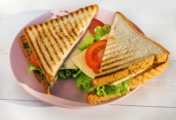 istock Two grilled sandwiches with cheese, lettuce and tomatoes lie on a plate 1397205690