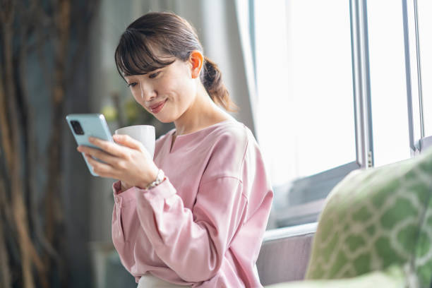 istock A woman relaxing on the sofa while holding a smartphone 1397206594