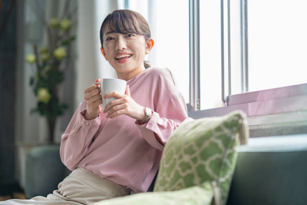 istock A woman relaxing on the sofa while holding a smartphone 1397206625