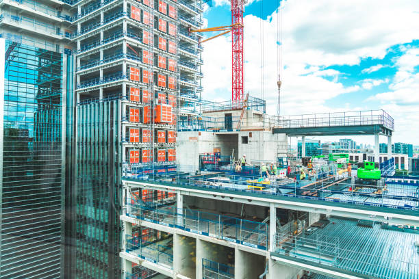 blick auf die baustelle mit unfertigen wohngebäuden gegen blauen himmel, london - city of london office building construction architecture stock-fotos und bilder