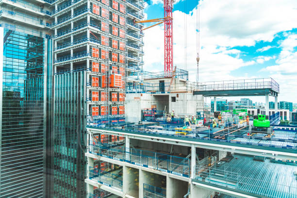 View at construction site with unfinished residential buildings against blue sky, London stock photo