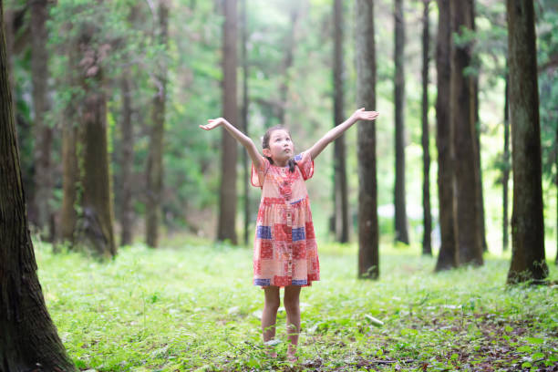 istock Girl is open arms in the woods 1397208380