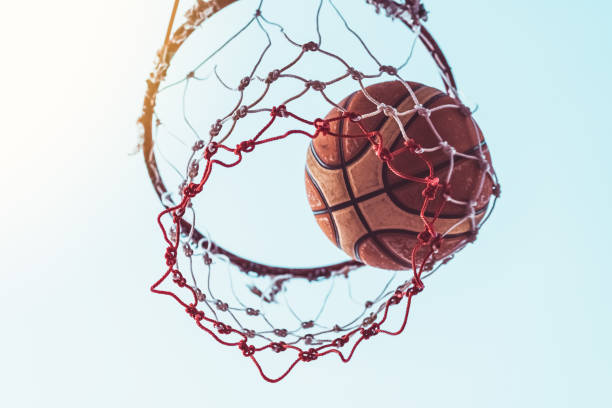 istock Basketball into the basket on blue sky abstract background 1397211221