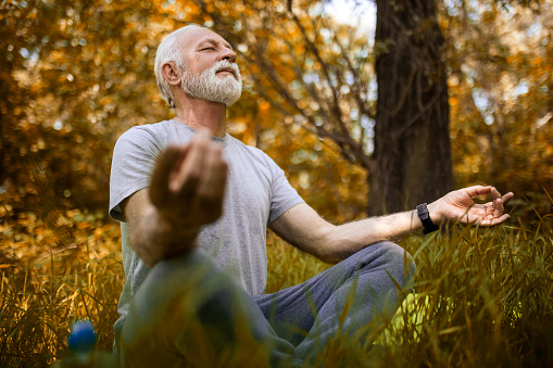 Senior Man in public park doing yoga