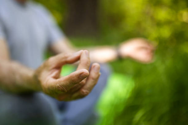 istock Unrecognizable senior an meditating in public park 1397211995