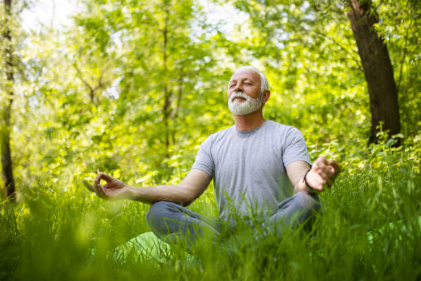 istock Senior Man meditating in public park 1397212003